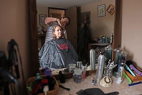 Iris Karton cuts and styles her daughter Meigan Oakley's hair after cutting off Oakley's 19-inch braid of hair in Oakley's basement hair studio Monday afternoon. (Tim Smith/The Brandon Sun)