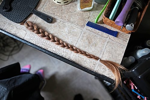 Meigan Oakley's braid of hair sits on a table after Oakley's mom Iris Karton cut it off in Oakley's basement hair studio Monday afternoon. (Tim Smith/The Brandon Sun)