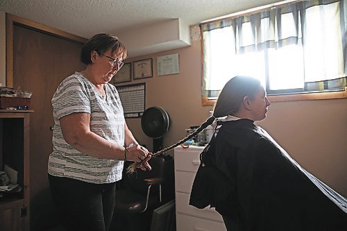 23012023
Iris Karton braids her daughter Meigan Oakley's hair in preparation to cut it in Oakley's basement hair studio on Monday afternoon. Oakley has been growing her hair for 10 years and will donate the cut hair to Wigs For Kids. She also donated her hair to the same organization a decade ago. (Tim Smith/The Brandon Sun)