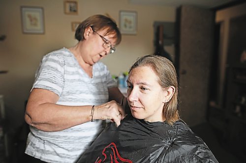 23012023
Iris Karton cuts and styles her daughter Meigan Oakley's hair after cutting off Oakley's 19 inch braid of hair in Oakley's basement hair studio on Monday afternoon. Oakley has been growing her hair for 10 years and will donate the hair to Wigs For Kids. She also donated her hair to the same organization a decade ago. (Tim Smith/The Brandon Sun)