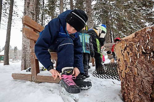 25012023
Zander Plett ties his ice skates as his dad Ty builds a fire so Zander and his siblings can roast hotdogs during a day of adventure in Wasagaming at Riding Mountain National Park on a mild Wednesday afternoon. 
(Tim Smith/The Brandon Sun)