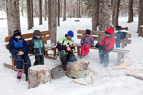 25012023
Ty Plett builds a fire so he and his children Zander, Dev, Ari and Cohen can roast hotdogs during a day of adventure in Wasagaming at Riding Mountain National Park on a mild Wednesday afternoon. 
(Tim Smith/The Brandon Sun)