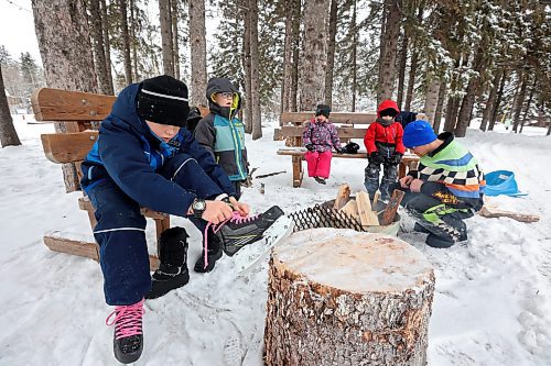 25012023
Zander Plett ties his ice skates as his dad Ty builds a fire so Zander and his siblings can roast hotdogs during a day of adventure in Wasagaming at Riding Mountain National Park on a mild Wednesday afternoon. 
(Tim Smith/The Brandon Sun)