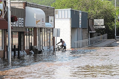 Brandon Sun 29062020

Jesse Hunt walks his bike through flood water inundating Main Street in Minnedosa on Monday after heavy downpours Sunday evening into overnight caused widespread flooding. The swollen Little Saskatchewan River overflowed into downtown Minnedosa flooding several businesses and residences. (Tim Smith/The Brandon Sun)