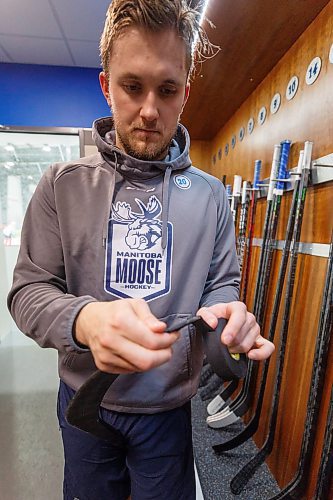 MIKE DEAL / WINNIPEG FREE PRESS
Manitoba Moose Kristian Reichel (20) tapes up a stick after practice at the Hockey For All Centre Thursday.
See Dave Sanderson story
230126 - Thursday, January 26, 2023.