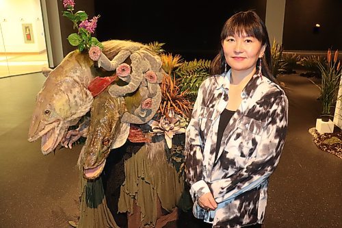 Edmonton-based artist Emily Jan poses for a photo at the Art Gallery of Southwestern Manitoba Friday morning, showcasing one of the key pieces of her "Kali Yuga" exhibition. (Kyle Darbyson/The Brandon Sun)