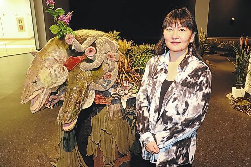 Edmonton-based artist Emily Jan poses for a photo at the Art Gallery of Southwestern Manitoba Friday morning, showcasing one of the key pieces of her "Kali Yuga" exhibition. (Kyle Darbyson/The Brandon Sun)