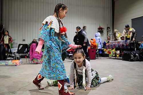 Meeka Hall taps Sophia Halfe on the head while Sophia does the splits while waiting for the powwow grand entry to commence on the opening evening of the Dakota Nation Winterfest at the Keystone Centre on Friday evening. (Tim Smith/The Brandon Sun)