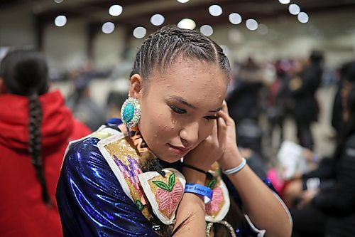 Cassie Demas of Canupawakpa Dakota Nation attaches her earrings while preparing for the powwow grand entry at the Dakota Nation Winterfest at the Keystone Centre on Friday evening. (Tim Smith/The Brandon Sun)