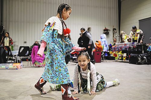 27012022
Meeka Hall taps Sophia Halfe on the head while Sophia does the splits while waiting for the powwow grand entry to commence on the opening evening of the Dakota Nation Winterfest at the Keystone Centre on Friday evening. After cancellations in 2021 and 2022 due to the COVID-19 pandemic, the annual event is back in the wheat city until Sunday and features a powwow, a talent show, hockey, volleyball and basketball tournaments, and much more. 
(Tim Smith/The Brandon Sun)