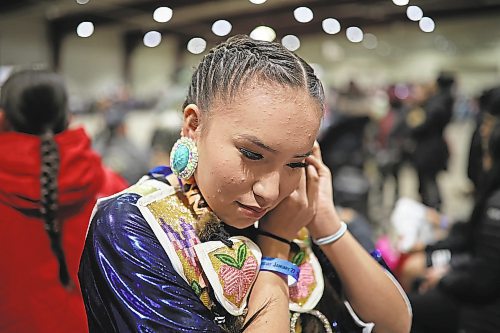 27012022
Cassie Demas of Canupawakpa Dakota Nation attaches her earrings while preparing for the powwow grand entry at the Dakota Nation Winterfest at the Keystone Centre on Friday evening. After cancellations in 2021 and 2022 due to the COVID-19 pandemic, the annual event is back in the wheat city until Sunday and features a powwow, a talent show, hockey, volleyball and basketball tournaments, and much more. 
(Tim Smith/The Brandon Sun)