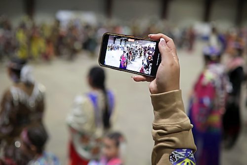 27012022
A woman films the powwow grand entry at the Dakota Nation Winterfest at the Keystone Centre on Friday evening. After cancellations in 2021 and 2022 due to the COVID-19 pandemic, the annual event is back in the wheat city until Sunday and features a powwow, a talent show, hockey, volleyball and basketball tournaments, and much more. 
(Tim Smith/The Brandon Sun)