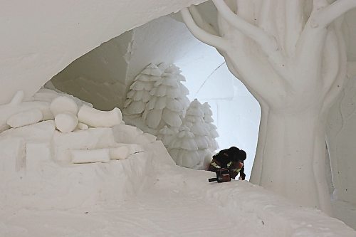 TYLER SEARLE / WINNIPEG FREE PRESS
The maze measures nearly 60,000 square feet and contains five buildings constructed from snow. The interior of each building features snow carvings and sculptures. On on Saturday, Feb. 28, 2023, a staff member was working inside.