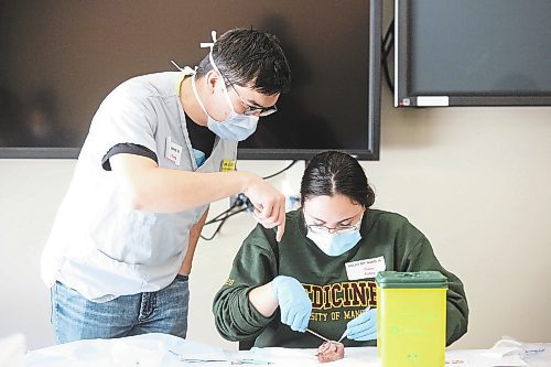 Dr. Adrian Fung, a family physician and anesthetist, instructs University of Manitoba medical student Claire Risbey on how to properly suture a wound Saturday afternoon at the Brandon Regional Health Centre. Risbey is one of 34 Rural Interest Group students from the U of M who visited the BRHC this past Friday and Saturday to learn what it's like to work at a remote medical facility. (Kyle Darbyson/The Brandon Sun)