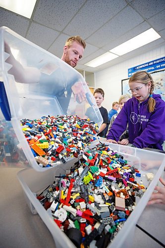 MIKE DEAL / WINNIPEG FREE PRESS
Jaidyn Smart (right) watches as teacher, Tim Morison (left), pours legos into a bin at the start of the noon-hour Lego Club at Starbuck School.
Tim Morison, phys-ed teacher at Starbuck School in Starbuck, MB, found in Lego an unlikely cure to workplace burnout and mental health challenges, which began after months of teaching during a pandemic and worsened when he and his wife lost their baby in the spring. Morison opened up to his students about his mental health struggles and shared his coping mechanism: building Lego with his three-year-old at home and alone, with them. His students&#x560;receptiveness has since sparked the launch of a Lego club at Starbuck School. On Mondays and Tuesdays, the phys-ed teacher forfeits his lunch hour to spend time with K-8 students and colourful blocks. They&#x576;e done significant fundraising to purchase toys and accepted donations from community members.
See Maggie Macintosh story
230130 - Monday, January 30, 2023.