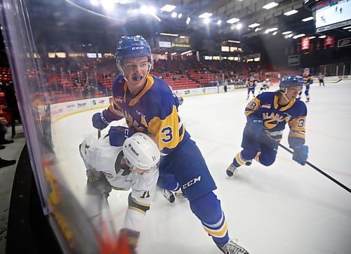 Blake Gustafson of the Saskatoon Blades drives Rylen Roersma of the Brandon Wheat Kings into the boards during Western Hockey League action at Westoba Place on Tuesday evening. The game was still in progress at press time. Head to brandonsun.com for the game story. (Photos by Tim Smith/The Brandon Sun)