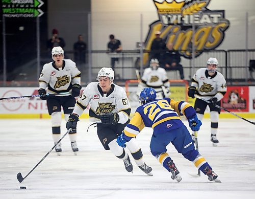 31012022
Matthew Henry #67 of the Brandon Wheat Kings plays the puck around Spencer Shugrue #26 of the Saskatoon Blades during WHL action at Westoba Place on Tuesday evening. 
(Tim Smith/The Brandon Sun)