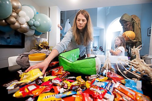 JOHN WOODS / WINNIPEG FREE PRESS
Kim Wlodarczyk, mother of two, goes through her children’s Halloween candy in her home as her daughter Chloe, 7, looks on in Winnipeg Monday, November 1, 2022. Several children in south Winnipeg received THC medicated gummies in their candy hauls.

Re: macintosh