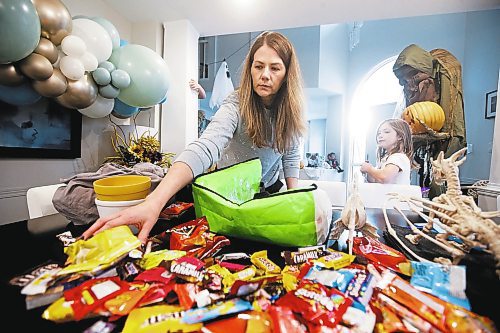 JOHN WOODS / WINNIPEG FREE PRESS
Kim Wlodarczyk, mother of two, goes through her children&#x2019;s Halloween candy in her home as her daughter Chloe, 7, looks on in Winnipeg Monday, November 1, 2022. Several children in south Winnipeg received THC medicated gummies in their candy hauls.

Re: macintosh