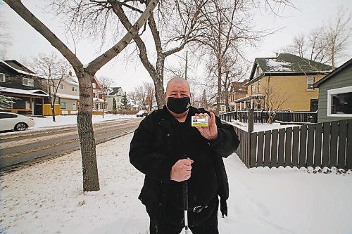 Brandon Sun Mike Thiessen holds up his ID card issued by the Canadian National Institute for the Blind. (Drew May/The Brandon Sun)