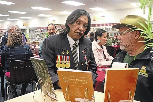 Tommy Prince Jr. inspects some literature on display at the Crocus Plains Regional Secondary School library that now bears his father's name as of Friday. (Kyle Darbyson/The Brandon Sun)