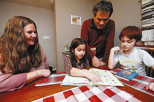 JOHN WOODS / WINNIPEG FREE PRESS
Jane Friesen and Ulises Cancino, who is from Chile, look over some spanish books with their children Noa, 6, and Ian, 10, in their home Tuesday, February 7, 2023. The Winnipeg School division has extended itճ bilingual Spanish program at Earl Grey School.
 
Re: macintosh