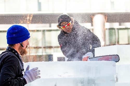 MIKAELA MACKENZIE / WINNIPEG FREE PRESS

Victor Dagatan cuts an ice block to fit on the stack as Nate McKeough holds it in place in preparation for ice carving at True North Square in Winnipeg on Tuesday, Feb. 7, 2023. For &#x460;story.

Winnipeg Free Press 2023.