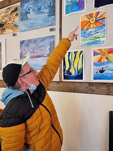 Stanley Szwagierczak points out a painting he created which was on display at the art gallery at Brews Brothers Bistro in Neepawa earlier this month. (Miranda Leybourne/The Brandon Sun)