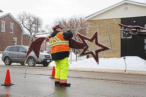 City of Brandon Parks department employee Ryan Savage loads the last of the city's hanging Christmas decorations on the back of a truck on Princess Avenue on Monday morning. (Matt Goerzen/The Brandon Sun)