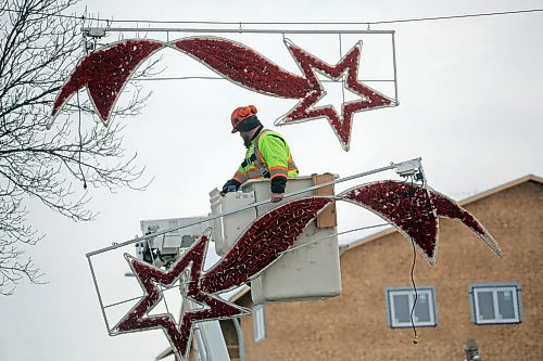 Mike Hutch, a trades worker with the City of Brandon's parks department, holds one of a pair of shooting star Christmas decorations that were removed along Princess Avenue on Wednesday morning. This particular pair marked the last of the downtown hanging Christmas decorations to be removed for the season. (Matt Goerzen/The Brandon Sun)