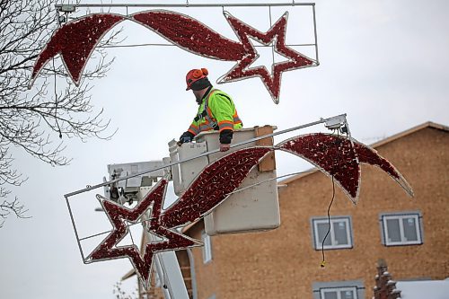 Mike Hutch, a trades worker with the City of Brandon's parks department, holds one of a pair of shooting star Christmas decorations that were removed along Princess Avenue on Wednesday morning. This particular pair marked the last of the downtown hanging Christmas decorations to be removed for the season. (Matt Goerzen/The Brandon Sun)