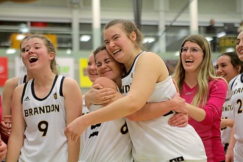 Chelsea Misskey, centre, hugs Eden Tabin after the Brandon University Bobcats first Canada West women's basketball win of the season, 82-79 over UNBC on Friday. (Thomas Friesen/The Brandon Sun)