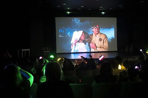 Attendees of Brandon Pride's Friday night screening of "The Rocky Horror Picture Show" break out some glow sticks during the film's musical number titled "Over at the Frankenstein Place." (Kyle Darbyson/The Brandon Sun)