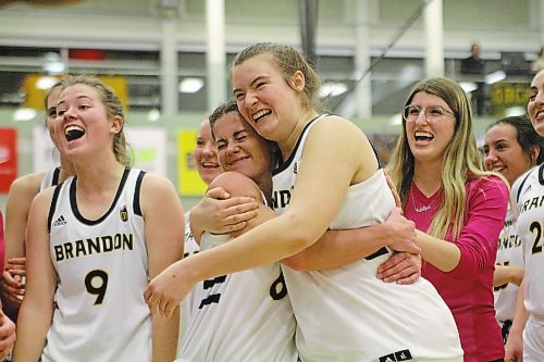 Chelsea Misskey, centre, hugs Eden Tabin after the Brandon University Bobcats first Canada West women's basketball win of the season, 82-79 over UNBC on Friday. (Thomas Friesen/The Brandon Sun)