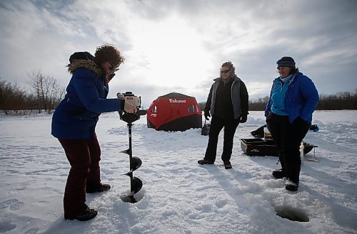 JOHN WOODS / WINNIPEG FREE PRESS
Dana Urbanski drills a hole with an auger as her sister Sherry, centre, and Roselle Turenne, owner of Prairie Gal Fishing, look on during a fishing workshop on a lake at FortWhyte Alive.