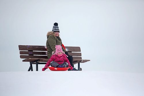 Minto resident Stephanie MacDonald watches her six-year-old daughter Madison MacDonald get read to sled down from the top of Hanbury Hill on a windy Tuesday afternoon in Brandon. (Matt Goerzen/The Brandon Sun)