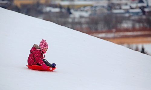 Six-year-old Madison MacDonald from Minto smiles while gliding down Hanbury Hill with her saucer sled on a windy Tuesday afternoon. (Matt Goerzen/The Brandon Sun)