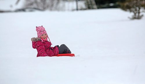 Six-year-old Madison MacDonald from Minto smiles after completing her sled down Hanbury Hill on a windy Tuesday afternoon. (Matt Goerzen/The Brandon Sun)