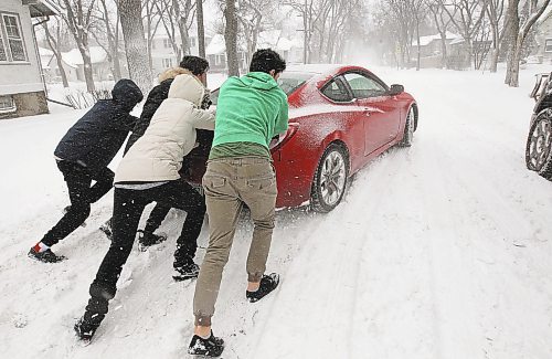 JOE BRYKSA / WINNIPEG FREE PRESS  L to R- Farhad Naso, Alex Kirbyson, Chelsea Bolton, Tyler Vincent help a man who&#x2019;s sports car was stuck in snow and ice on Kingsway on River Heights in  Winnipeg &#x2013; The city and southern Manitoba will have winter storm/ blizzard conditions for the day-  Dec 06, 2016 -( standup Photo)