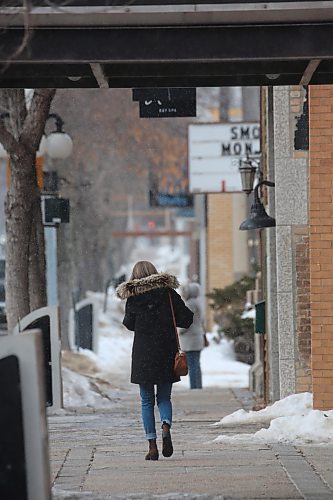 A woman walks westbound on the sidewalk outside of Scotia Towers on Rosser Avenue on Wednesday afternoon. (Matt Goerzen/The Brandon Sun)