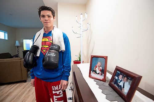 Mike Sudoma/Winnipeg Free Press
Local boxer Eli Serada stands beside a baby picture of him as a 7 week year old wearing boxing gloves and a boxing towel around his neck Thursday evening
February 16, 2023 