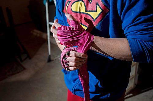 Mike Sudoma/Winnipeg Free Press
Eli Serada warps his hands prior to training inside of his garage boxing gym set up Thursday evening
February 16, 2023 