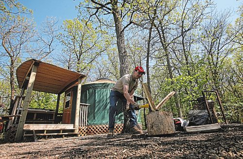 Brandon Sun Drew Richardson splits wood for the fire outside one of the yurts set amongst the oaks at the Kiche Manitou campground in Spruce Woods Provincial Park. For Charles. (Bruce Bumstead/Brandon Sun)