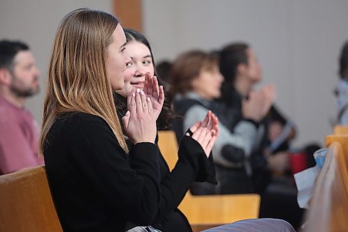 Devin Kerman-Forsythe looks over at her friend Dannah Pentney while applauding for a fellow participant in the Festival of the Arts competition, held at Knox United Church on Friday afternoon. The two young women were among several Brandon students to compete in solo singing performances this week.  (Matt Goerzen/The Brandon Sun)