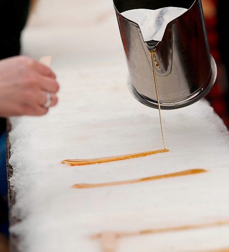 JOHN WOODS / WINNIPEG FREE PRESS
People pour maple syrup onto snow to make maple taffy at the Festival du Voyageur in Winnipeg, Sunday, February 19, 2023. 

Re: pindera