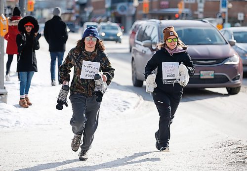 JOHN WOODS / WINNIPEG FREE PRESS
Athletes run down Osborne as they compete in the team skate relay race at the Beer Can Olympics outside the Gas Station Theatre in Osborne Village in Winnipeg, Sunday, February 19, 2023. 

Re: ?