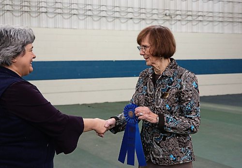 Judge Gail Carroll awards the blue ribbon to a contestant and her dog at the Crocus Obedience and Kennel Club's annual obedience trials and confirmation shows. (Michele McDougall The Brandon Sun)