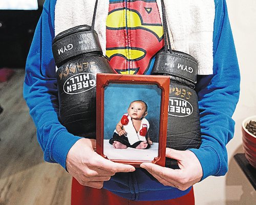 Mike Sudoma/Winnipeg Free Press
Local boxer Eli Serada holds up an image of him as a 7 week year old wearing boxing gloves and a boxing towel around his neck Thursday evening
February 16, 2023 