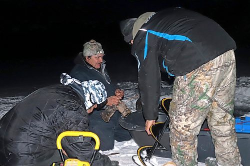 Members of Keeseekoowenin Ojibway First Nation battle the severe cold on Thursday night to set up some fishing nets at Clear Lake just off the shores of Wasagaming. Anishinaabe language coordinator Carolynn Brazeau later told the Sun that this activity is part of an ongoing joint venture between Keeseekoowenin and Parks Canada, where the federal body is allowing Indigenous groups to reclaim some of their traditional cultural practices within Riding Mountain National Park. In the early 20th century, the federal government expelled the Keeseekoowenin from their traditional land in order to establish this territory as a national park. Only recently has Parks Canada taken steps to try and correct these past mistakes by working more directly with Keeseekoowenin and other Indigenous bands in the region. (Kyle Darbyson/The Brandon Sun)
