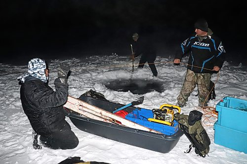 Members of Keeseekoowenin Ojibway First Nation battle the severe cold on Thursday night to set up some fishing nets at Clear Lake just off the shores of Wasagaming. Anishinaabe language coordinator Carolynn Brazeau later told the Sun that this activity is part of an ongoing joint venture between Keeseekoowenin and Parks Canada, where the federal body is allowing Indigenous groups to reclaim some of their traditional cultural practices within Riding Mountain National Park. In the early 20th century, the federal government expelled the Keeseekoowenin from their traditional land in order to establish this territory as a national park. Only recently has Parks Canada taken steps to try and correct these past mistakes by working more directly with Keeseekoowenin and other Indigenous bands in the region. (Kyle Darbyson/The Brandon Sun)
